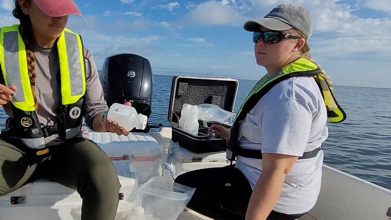 Two female district employees on a boat