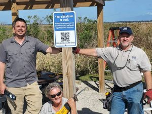 District workers standing next to a QR code sign