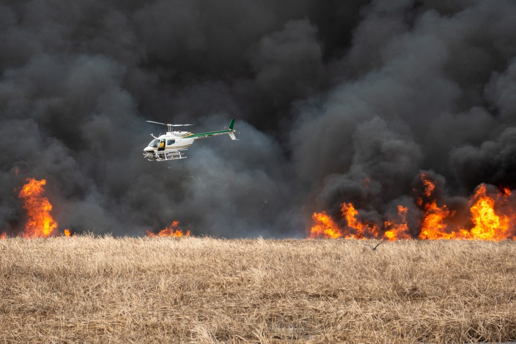 District staff ignite a prescribed fire from a helicopter