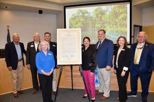 Board members standing by a proclamation