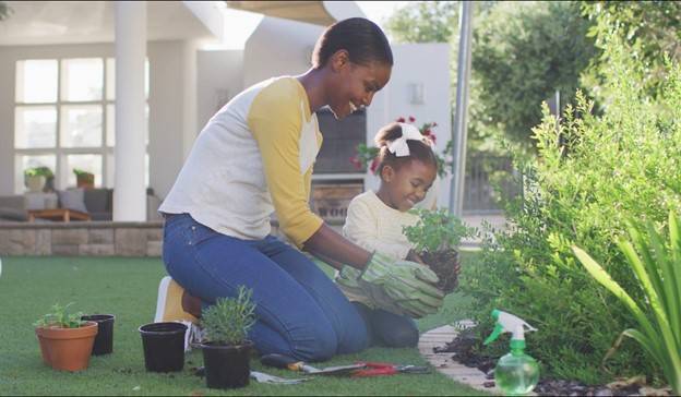 Mother and daughter planting in a garden