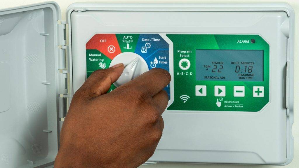 Person setting a sprinkler automatic shut-off timer