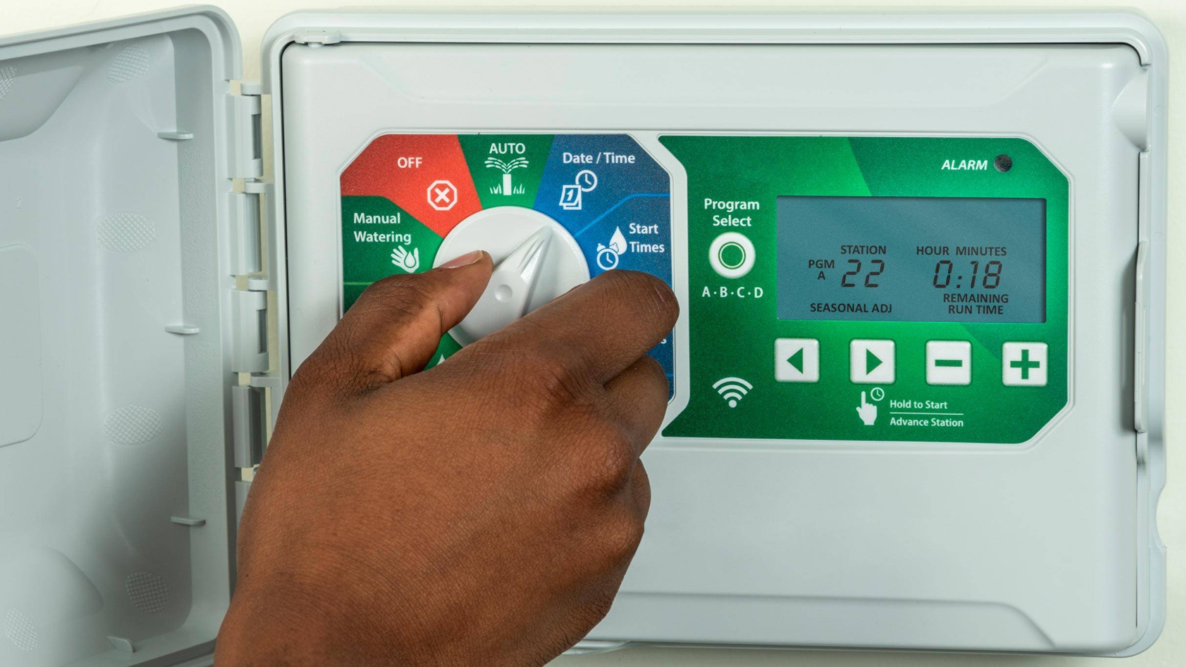 Person setting a sprinkler automatic shut-off timer