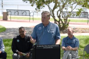 Mike Register welcomes guests at a podium