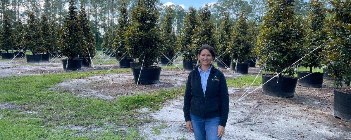 Tracy Rivera standing in a young grove