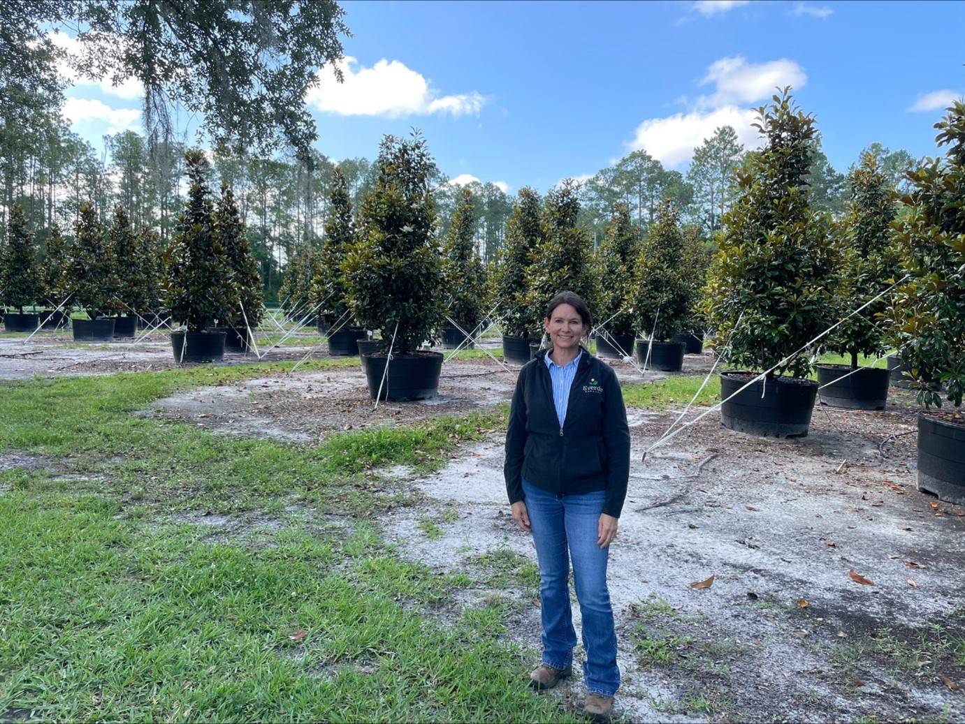 Tracy Rivera standing in a young grove