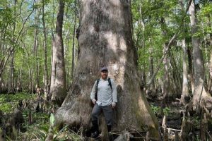 Man standing next to a large tree