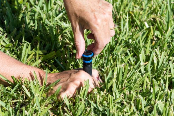 Irrigation system maintenance - Adjusting sprinkler Man Adjusting a sprinkler