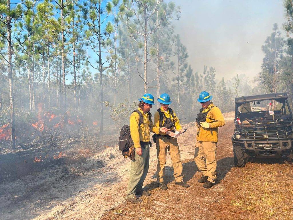 3 district fire fighters standing together