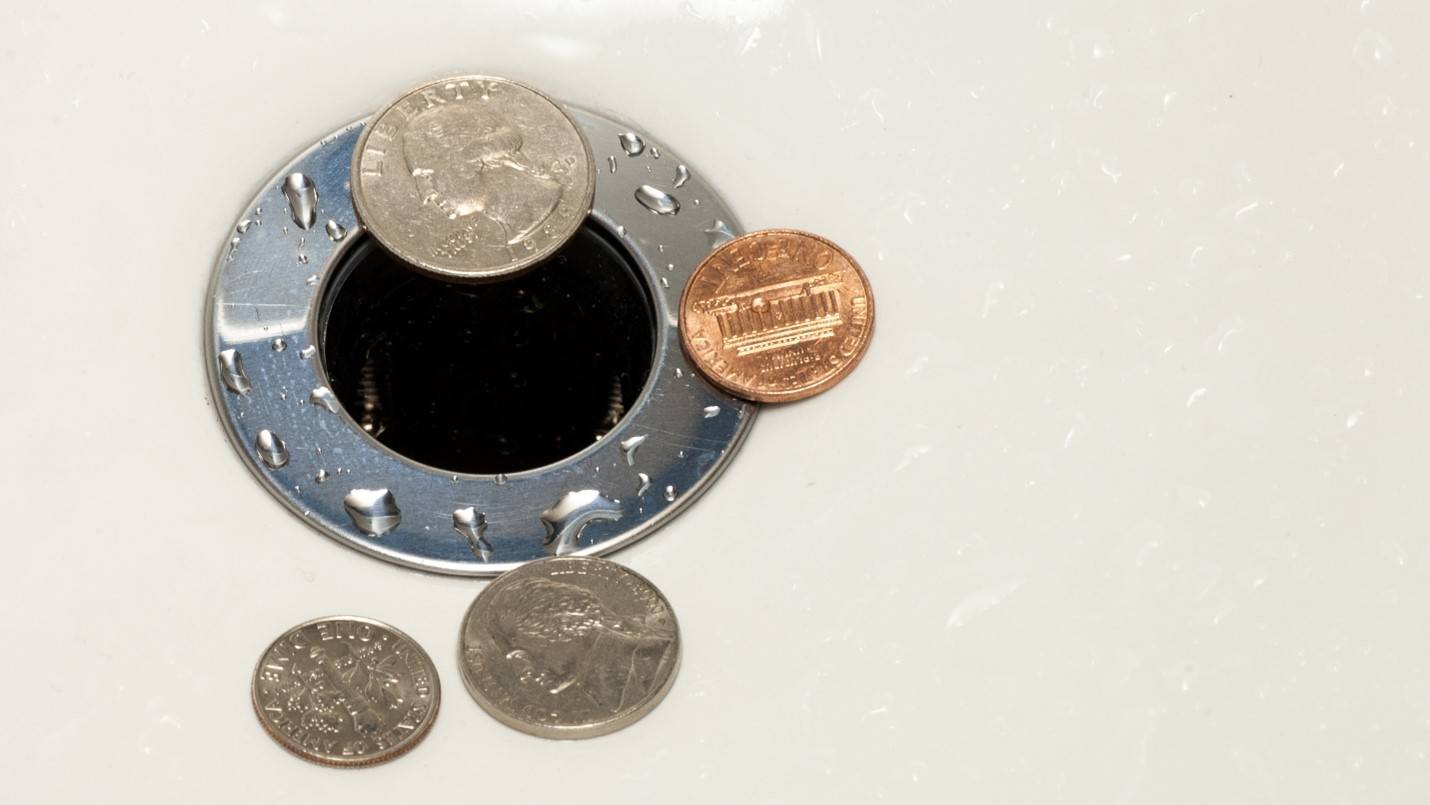 Coins lying next to a drain