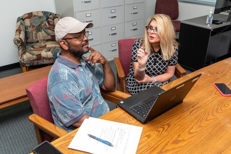 Two people working at a computer together