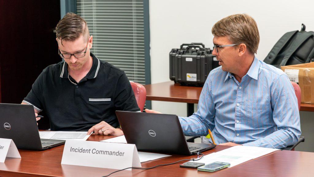 Two people working at computers during a meeting
