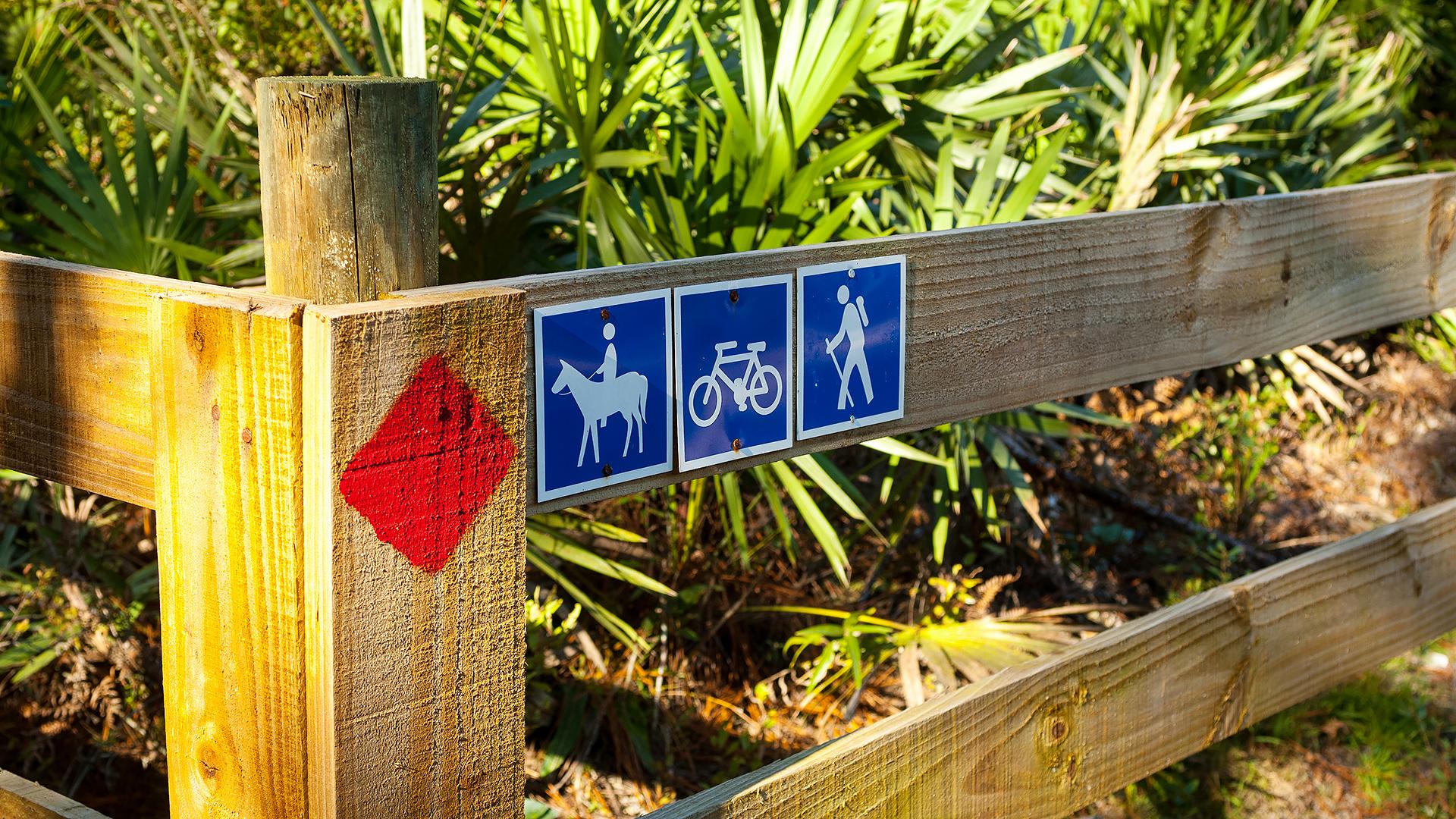 Trail markers on a wooden fence