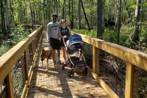 a couple walking down a boardwalk