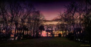 Photo of sunrise with visitors standing on a watch tower