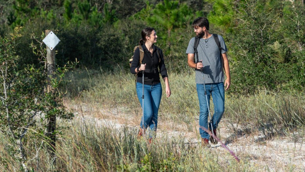 Two people walking on a trail in the woods