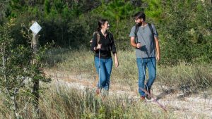 Two people walking on a trail in the woods