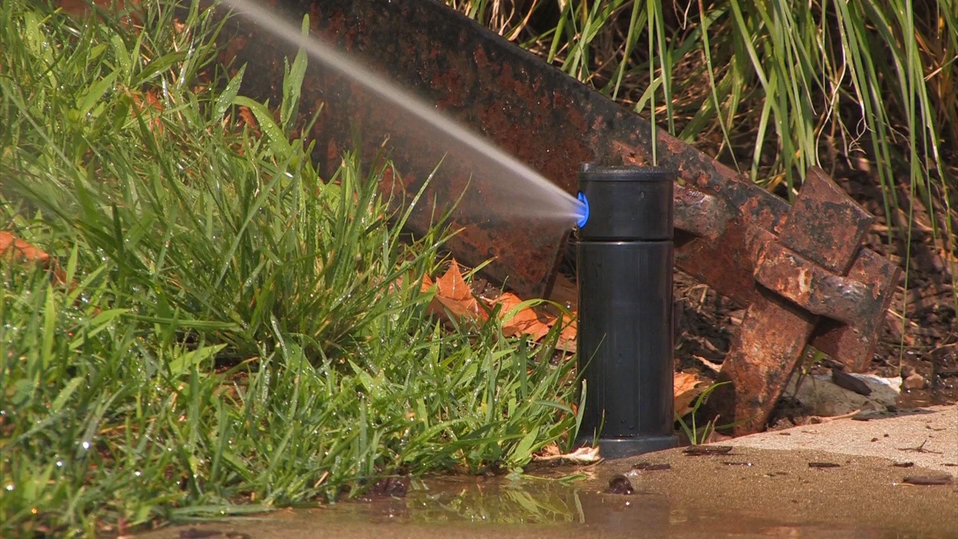 Irrigation sprinkler with water spraying on grass