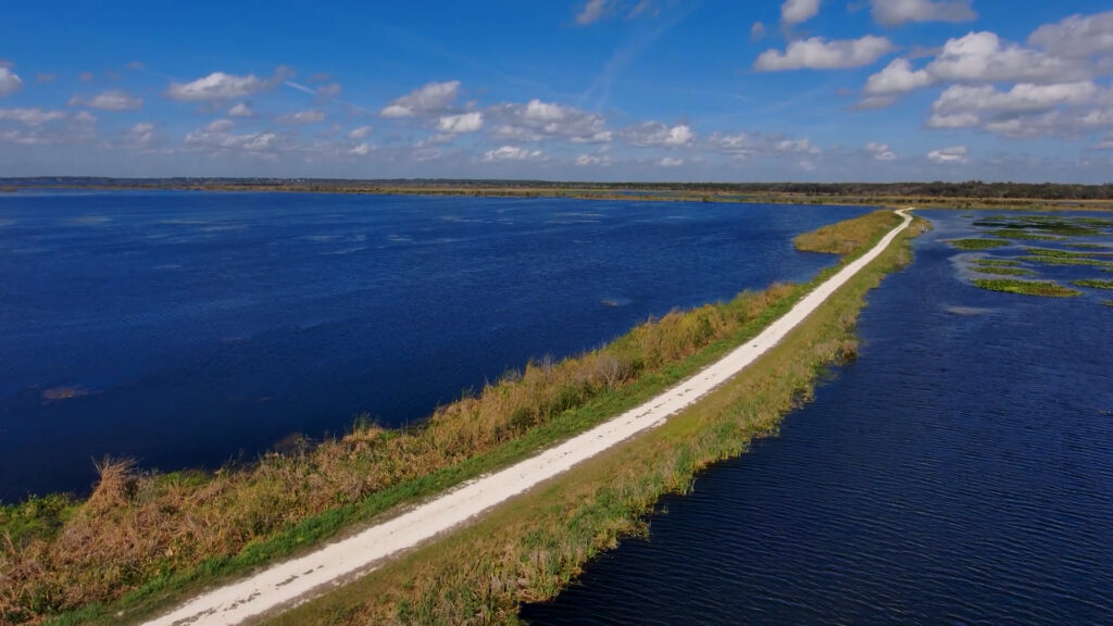 aerial view of a dirt road bordered by water