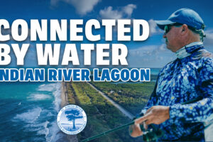 IRL-Thumbnail Promotional banner for the St. Johns River Water Management District showing an aerial view of the Indian River Lagoon shoreline and a man in fishing gear, with large text reading ‘Connected by Water – Indian River Lagoon.’