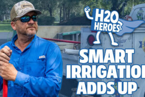 Promotional graphic for H2O Heroes: Smart Irrigation Adds Up, showing a person in a blue work shirt holding a red-handled tool beside an irrigation service truck, with the H2O Heroes logo and campaign title.