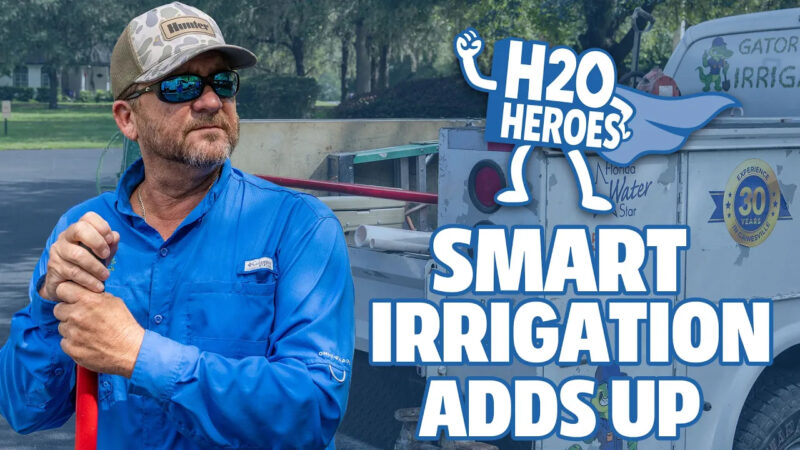 Promotional graphic for H2O Heroes: Smart Irrigation Adds Up, showing a person in a blue work shirt holding a red-handled tool beside an irrigation service truck, with the H2O Heroes logo and campaign title.